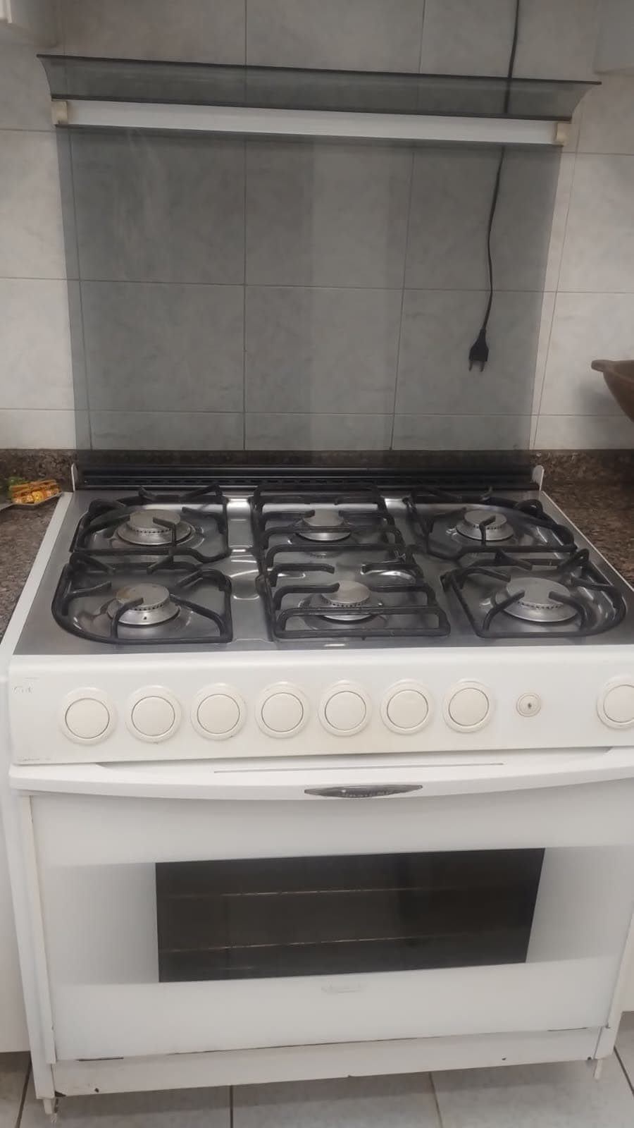 O fogão de seis bocas com forno, na cozinha